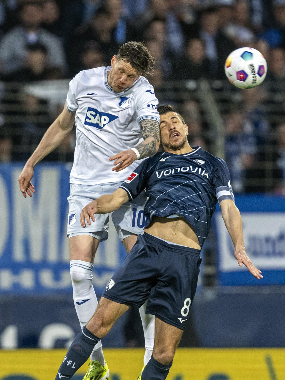 Hoffenheim's Wout Weghorst, left, and Bochum's Anthony Losilla battle for the ball during the Bundesliga soccer match between VfL Bochum - TSG 1899 Hoffenheim at Vonovia Ruhrstadion, Bochum, Germany, Friday April 26, 2024. (David Inderlied/dpa via AP)