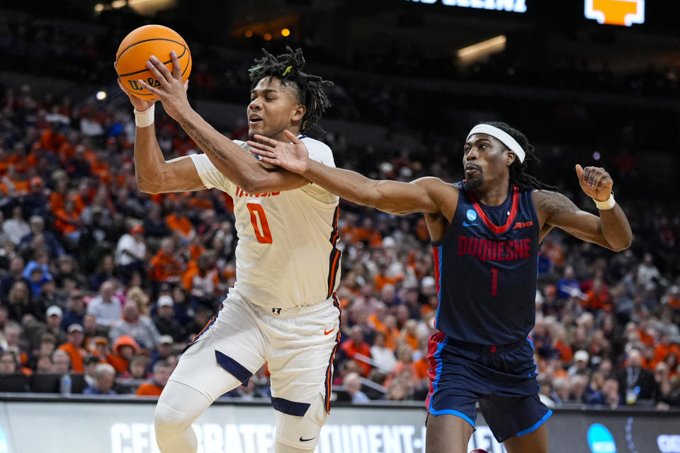 Illinois guard Terrence Shannon Jr. (0) grabs a loose ball in front of Duquesne guard Jimmy Clark III (1) in the second half of a second-round college basketball game in the NCAA Tournament, Saturday, March 23, 2024, in Omaha, Neb. (AP Photo/Charlie Neibergall)