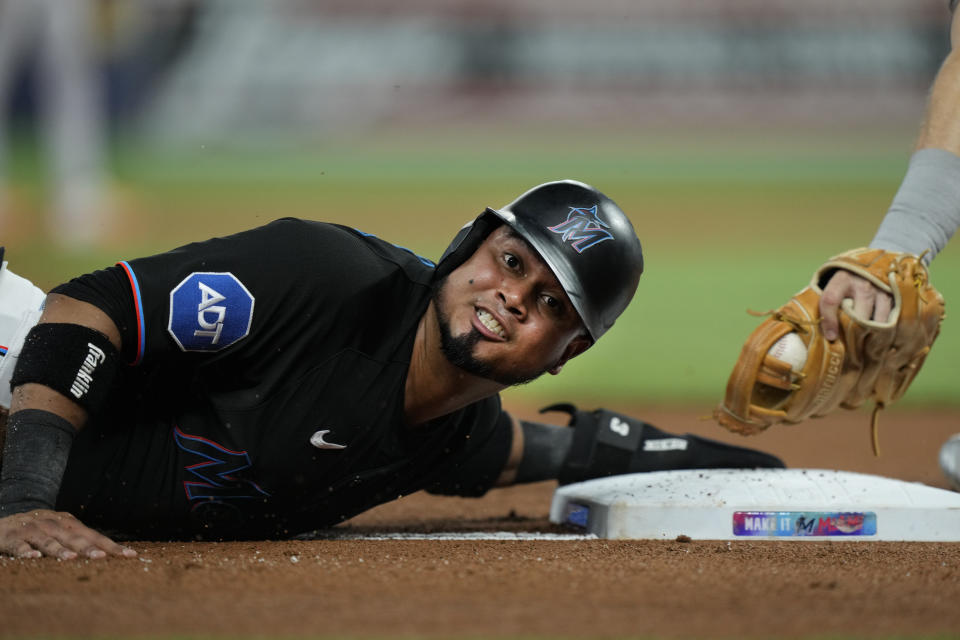 Miami Marlins' Luis Arraez reacts as he slides into third base on a single by Josh Bell during the first inning of a baseball game against the Houston Astros, Wednesday, Aug. 16, 2023, in Miami. (AP Photo/Wilfredo Lee)