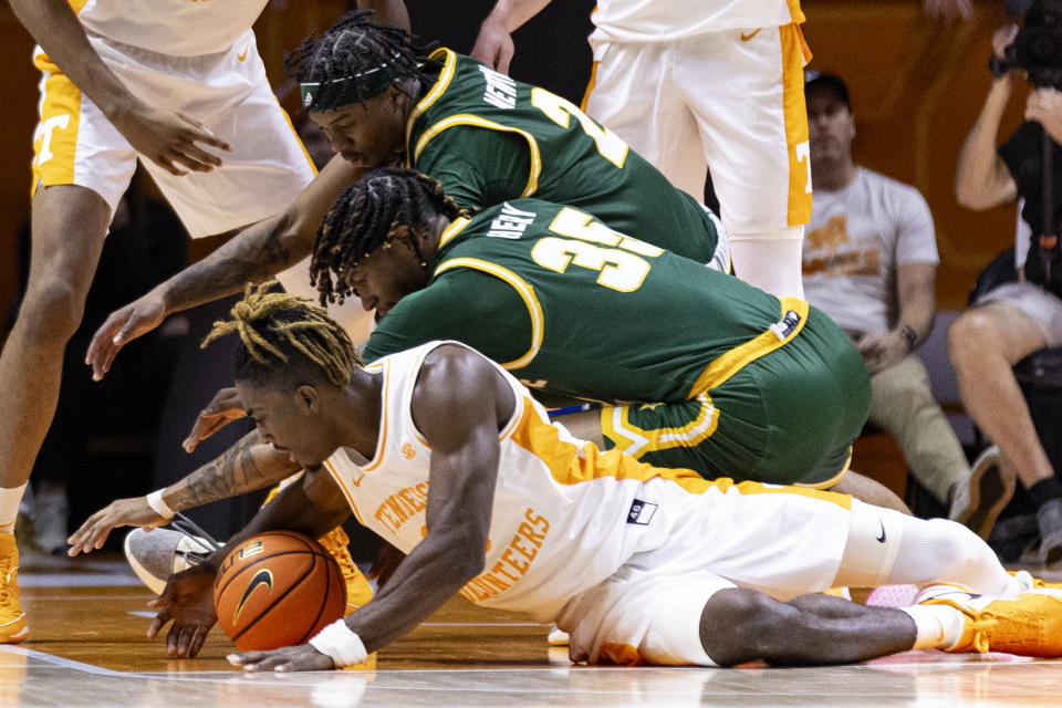Tennessee guard Jahmai Mashack (15) battles for the ball with George Mason forward Malik Henry (35) and guard Woody Newton (2) during the first half of an NCAA college basketball game Tuesday, Dec. 5, 2023, in Knoxville, Tenn. (AP Photo/Wade Payne)