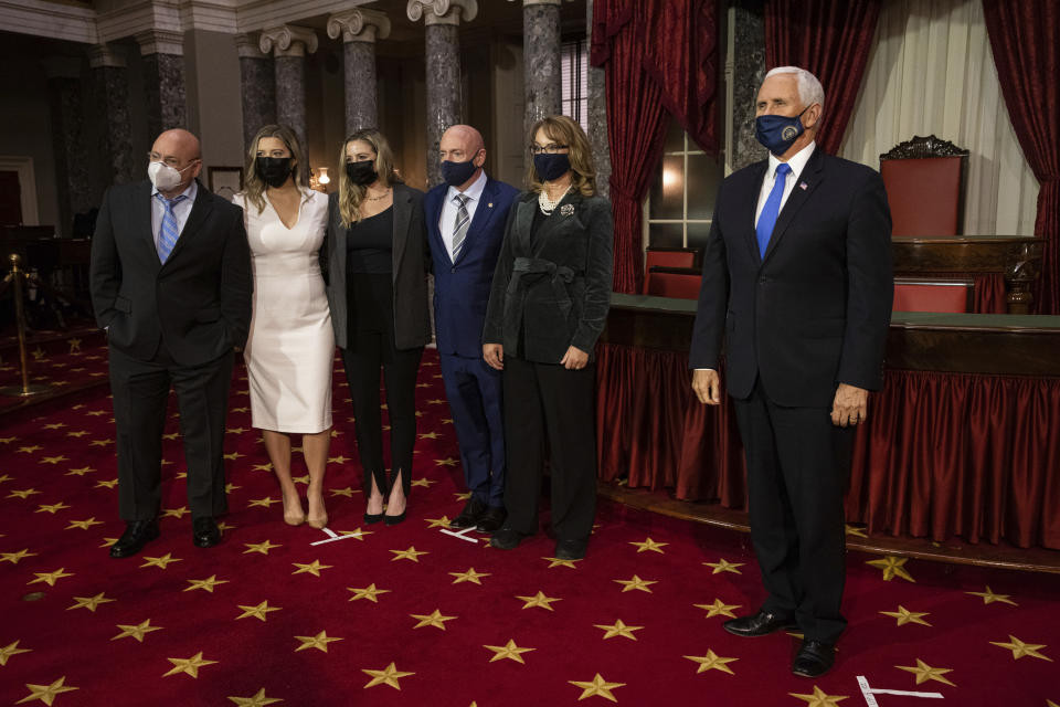 Sen. Mark Kelly, D-Ariz., third from right, poses for a photo with from left, his brother Scott Kelly, daughters Claire Kelly and Claudia Kelly, wife former Rep. Gabby Giffords, D-Ariz., and Vice President Mike Pence, in the Old Senate Chamber on Capitol Hill in Washington, Wednesday, Dec. 2, 2020, after participating in a re-enactment of his swearing-in. (Graeme Jennings/Pool via AP)