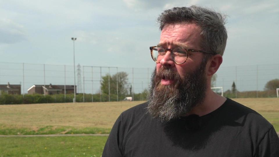 An image of Sam Hunt with a big beard and wearing a black top