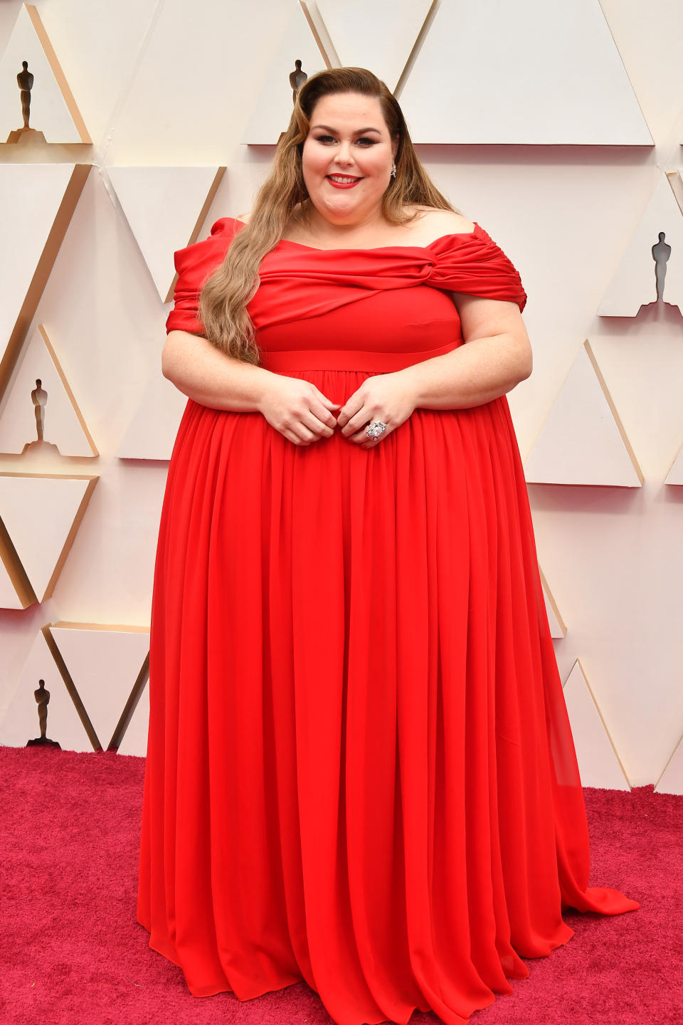 The "This Is Us" star opted for a bright red gown by Christian Siriano for the Oscars red carpet. Metz will perform the nominated song "I'm Standing With You," written by famed songwriter Diane Warren.