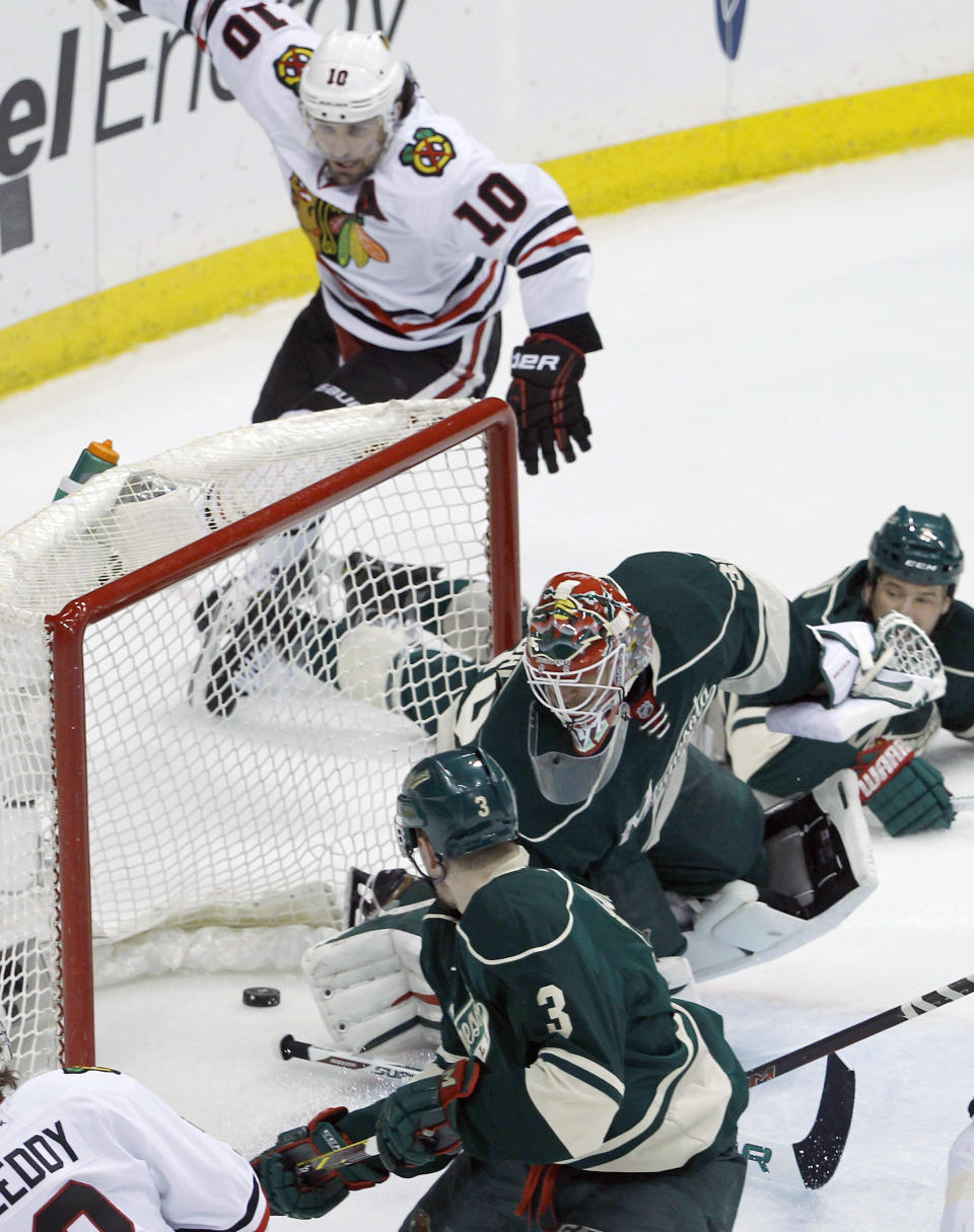 Minnesota Wild goalie Ilya Bryzgalov, center, and Wild center Charlie Coyle (3) are near as a shot by Chicago Blackhawks left wing Patrick Sharp (10) goes in during the first period of Game 4 of an NHL hockey second-round playoff series in St. Paul, Minn., Friday, May 9, 2014. (AP Photo/Ann Heisenfelt)