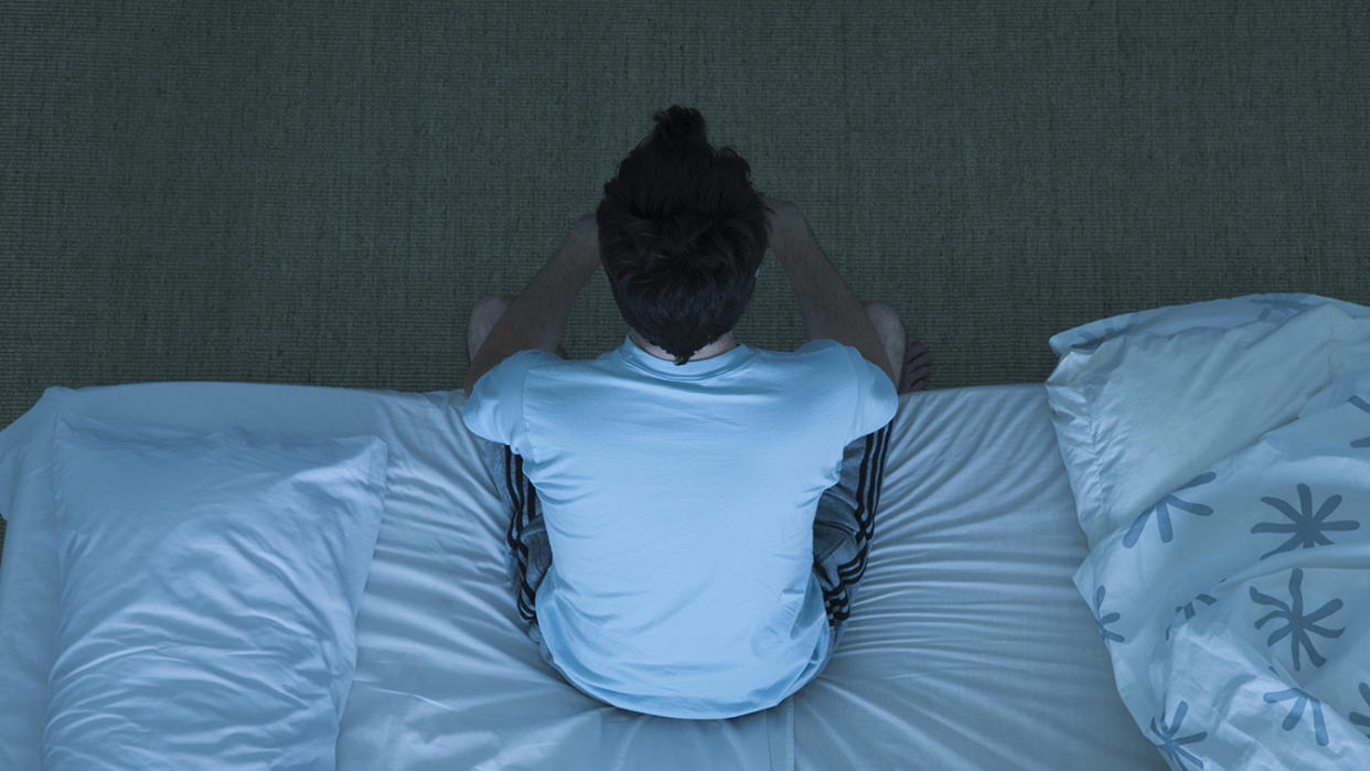 Photo of a person sitting up in bed.