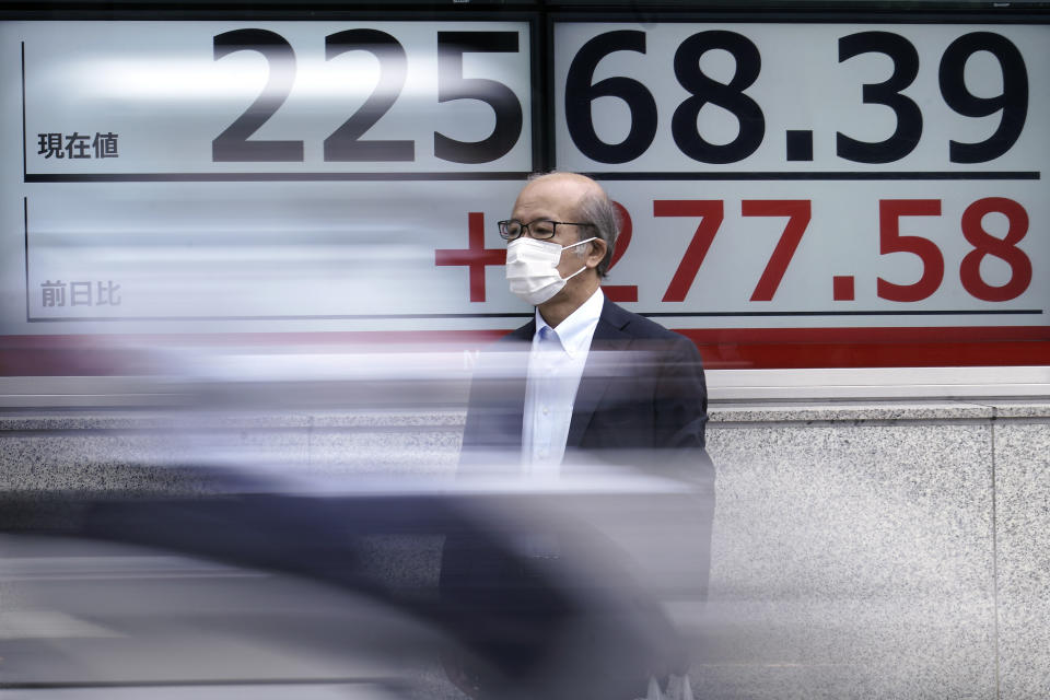 A man wearing a face mask to help curb the spread of the coronavirus stands near an electronic stock board showing Japan's Nikkei 225 index at a securities firm in Tokyo Monday, July 13, 2020. Asian shares rose Monday, cheered by recent upbeat projections on a global rebound tempered with worries about disappointment that could follow.(AP Photo/Eugene Hoshiko)