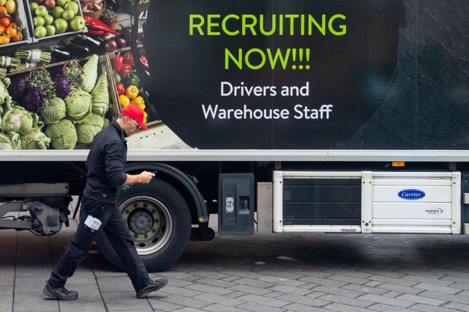 An advert for drivers and warehouse staff on the side of a lorry (PA)