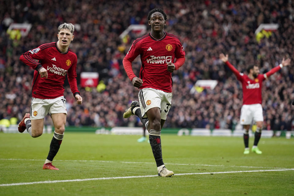 Manchester United's Kobbie Mainoo, centre, celebrates after scoring his side's second goal during the English Premier League soccer match between Manchester United and Liverpool at the Old Trafford stadium in Manchester, England, Sunday, April 7, 2024. (AP Photo/Dave Thompson)