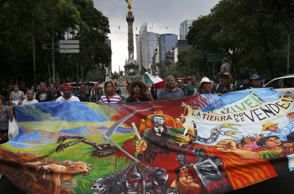 Residents who live in Atenco march against the construction of a new airport near their community, in Mexico City, Thursday, Aug. 23, 2018. Demonstrators marched through Mexico City Wednesday to protest a $15.7-billion airport project that threatens a decades-old effort to restore lakes that originally covered the valley. (AP Photo/Marco Ugarte)