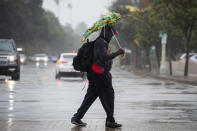 MoShawn Moore attempts to stay dry using a borrowed umbrella while walking to a bus stop on Colorado Boulevard in Pasadena, Calif., during a rainstorm, Monday, Oct. 25, 2021. (Sarah Reingewirtz/The Orange County Register via AP)