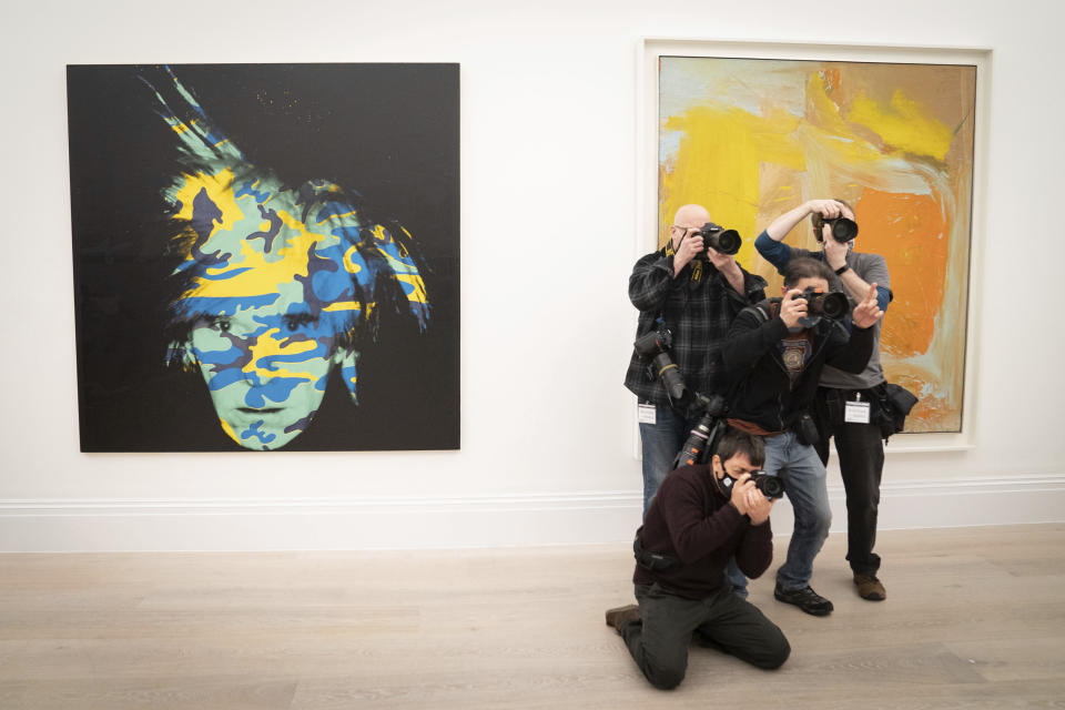 Fotógrafos toman imágenes junto a un autorretrato de Andy Warhol durante una sesión para las obras de la Colección Macklowe, que serán subastadas en Nueva York, en la casa de subastas Sotheby's de Londres el viernes 18 de febrero de 2022. Obras de arte de Pablo Picasso, Mark Rothko, Andy Warhol y otros maestros modernos serán subastadas el 16 de mayo en Nueva York. Eran parte de la colección del desarrollador de propiedades Harry Macklowe y su esposa Linda, quienes la crearon a lo largo de 40 años y se separaron en 2016. Un juez ordenó que la colección fuera vendida como parte del acuerdo de divorcio. Las piezas están valuadas en cientos de millones de dólares. (Stefan Rousseau/PA via AP)