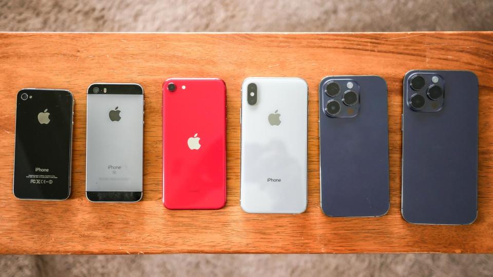 Various Apple iPhones stacked next to each other.