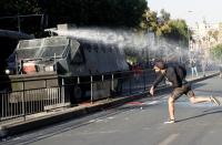 A demonstrator clashes with riot police during a protest against the increase in the subway ticket prices in Santiago