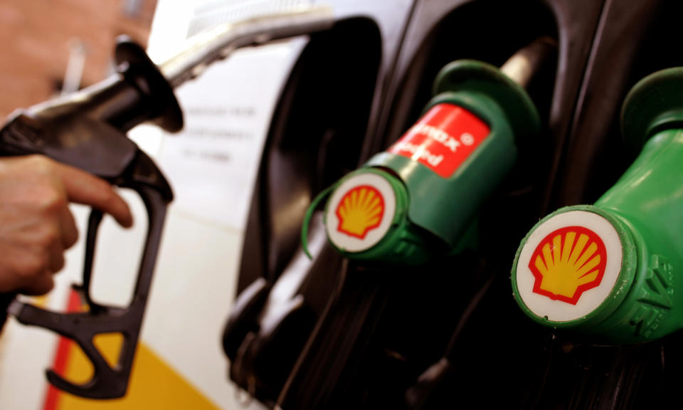 A man fills his car at a Shell garage in Glasgow, February 3, 2005. Royal Dutch/Shell Group issued another cut in reserves on Thursday, bigger than investors had expected, as the oil giant reported bumper fourth-quarter profits. Surging oil prices and strong refining margins enabled Shell to report fourth-quarter current-cost net earnings of $5.127 billion, including gains on one-off items of $318 million. NTRES REUTERS/Jeff J Mitchell  JJM/MD