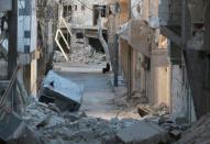 A woman sits amid damaged buildings in the rebel-held al-Myassar neighbourhood of Aleppo, Syria, September 27, 2016. REUTERS/Abdalrhman Ismail