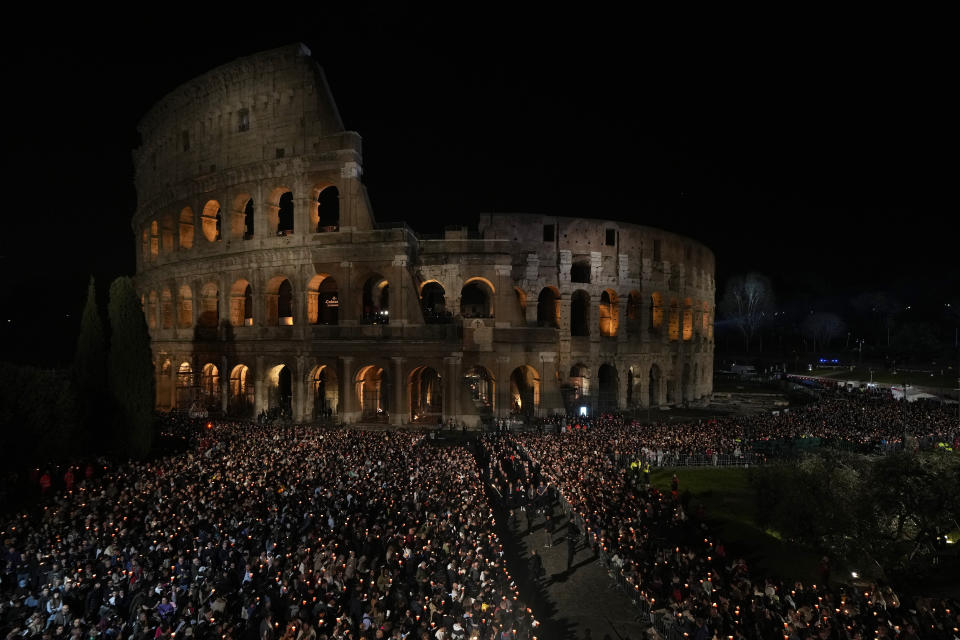 Faithful hold the cross as they take part in the Via Crucis (Way of the Cross) torchlight procession at the Colosseum on Good Friday, in Rome, Friday, March 29, 2024. (AP Photo/Andrew Medichini)