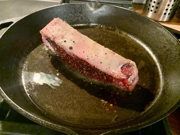 steak on its side in a pan