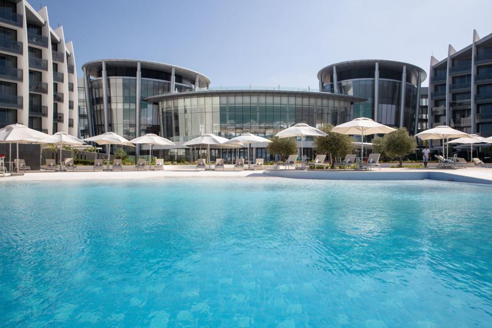 a pool with umbrellas by a building