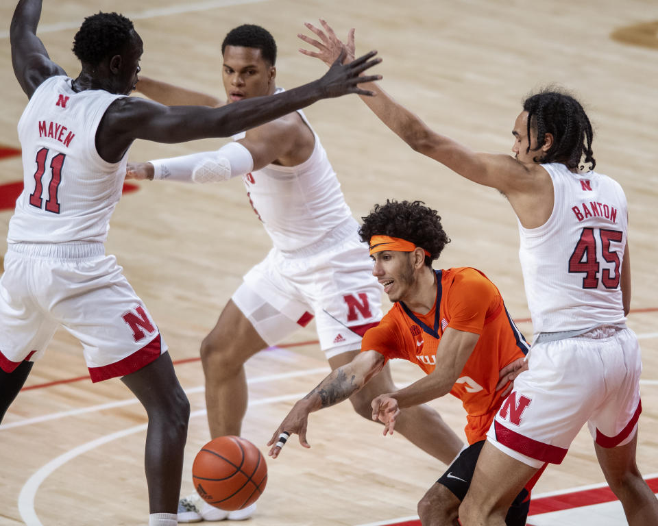 Illinois' Andre Curbelo (5) passes to a teammate as he's defended by Nebraska's Dalano Banton (45), Shamiel Stevenson (4) and Lat Mayen (11) during the first half of an NCAA college basketball game Friday, Feb. 12, 2021, in Lincoln, Neb. (Francis Gardler/Lincoln Journal Star via AP)