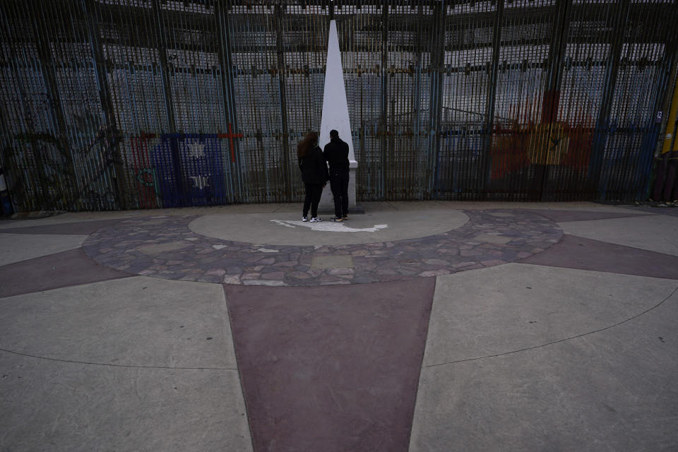 People look at the monument at Friendship Park, near where the border separating Tijuana, Mexico, and San Diego meets the Pacific Ocean Thursday, Jan. 19, 2021, in Tijuana, Mexico. In the days before Joe Biden became president, construction crews worked quickly to finish Donald Trump's wall at an iconic cross-border park overlooking the Pacific Ocean that then-first lady Pat Nixon inaugurated in 1971 as symbol of international friendship. (AP Photo/Gregory Bull)