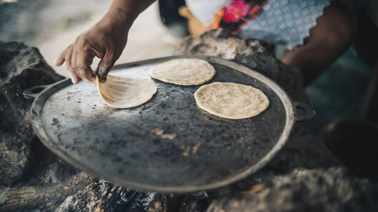 tortillas cooking on griddle