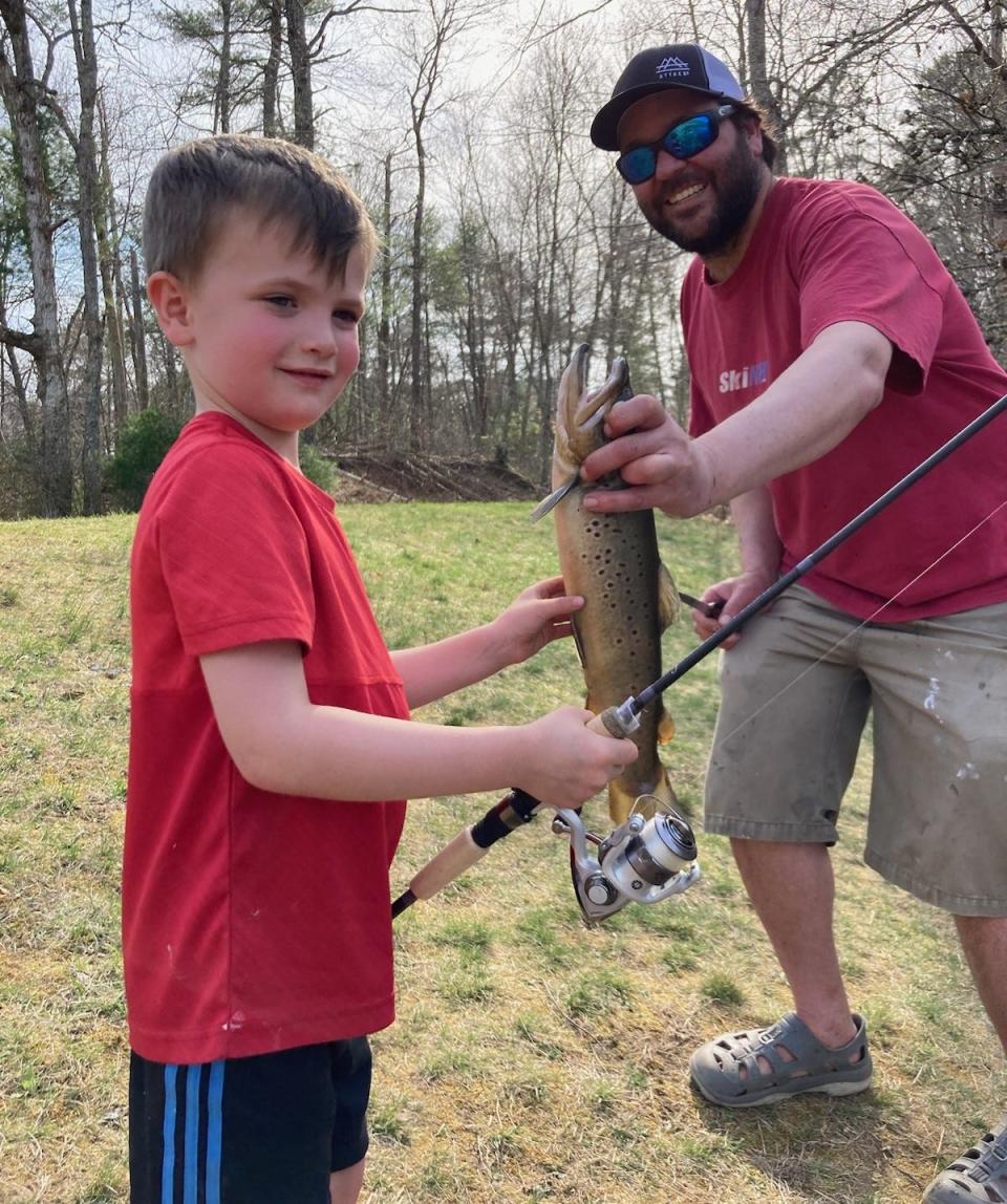 Henry Matoni, 5, of Charlestown and Matt Conti with the brown trout Henry caught at the Carolina Trout Pond in Richmond.