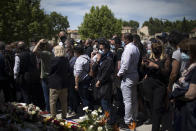 Police officers and civilians lay flowers at a police station in Avignon, southern France, Sunday, May 9, 2021. Police officers and civilians gathered to commemorate the death of a police officer who was killed Wednesday at a known drug-dealing site in the southern France city of Avignon. (AP Photo/Daniel Cole)