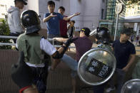 Police in riot gear try to separate students and local residents near the University of Hong Kong in Hong Kong, Saturday, Nov. 16, 2019. Rebellious students and anti-government protesters abandoned their occupation of nearly all of Hong Kong's universities Saturday after a near weeklong siege by police, but at least one major campus remained under control of demonstrators. (AP Photo/Ng Han Guan)