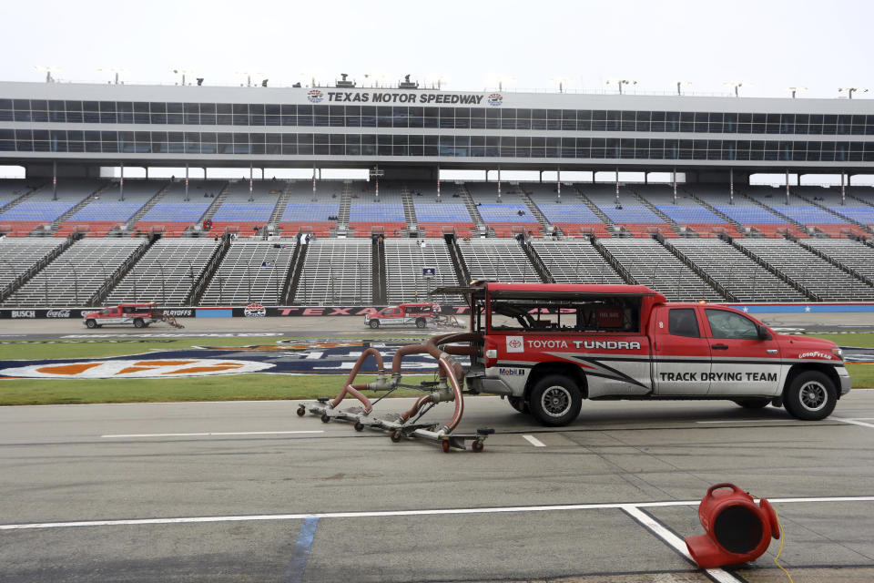 Trucks dry the track in an attempt to resume a NASCAR Cup Series auto race after morning rain prevented the  rescheduled start at Texas Motor Speedway in Fort Worth, Texas, Monday, Oct. 26, 2020. (AP Photo/Richard W. Rodriguez)