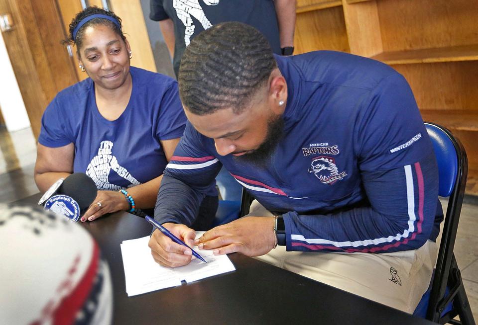Lori Thames watches her son Fabian sign his contract. The former Randolph High football standout signed with the Colorado-based American Raptors rugby team in front of many Randolph High athletes on Thursday, May 5, 2022.