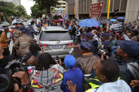 People run after the car that is transporting Oscar Pistorius from the high court after the first day of his trial in Pretoria, South Africa, Monday, March 3, 2014. Pistorius is charged with murder with premeditation in the shooting death of girlfriend Reeva Steenkamp in the pre-dawn hours of Valentine's Day 2013. (AP Photo/Schalk van Zuydam)