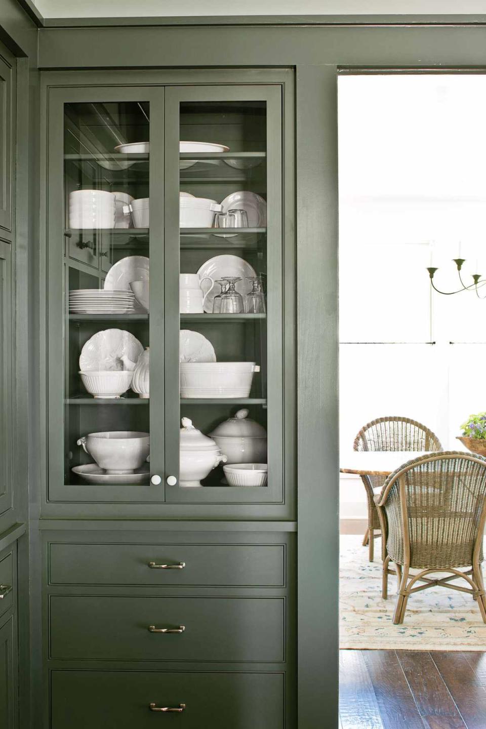 <p>A stately green-gray on the trim and glass-front cabinets makes the white china on display in the <a href="https://www.southernliving.com/home/idea-houses/nashville-idea-house-fontanel" rel="nofollow noopener" target="_blank" data-ylk="slk:2013 Southern Living Nashville Idea House;elm:context_link;itc:0;sec:content-canvas" class="link ">2013 Southern Living Nashville Idea House</a> really stand out. This is a great way to blend hues and create a space that feels warm yet crisp.</p>