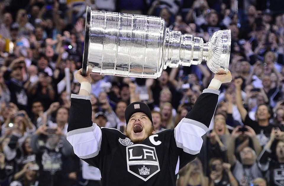 FILE - Los Angeles Kings right wing Dustin Brown (23) holds up the Stanley Cup after the Kings defeated the New Jersey Devils 6-1 in Game 6 of the NHL hockey Stanley Cup finals in Los Angeles, June 11, 2012. Former NHL players Dustin Brown and Jamie Langenbrunner highlight the 2023 U.S. Hockey Hall of Fame class unveiled Friday, Sept. 8, 2023, by USA Hockey. (AP Photo/Mark J. Terrill, File)