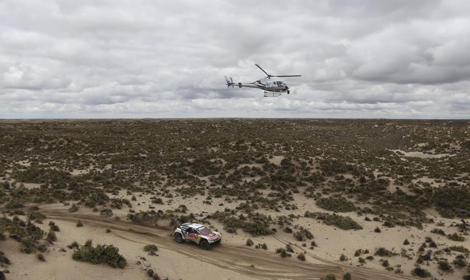 Driver Sebastien Loeb, of France, and co-driver Daniel Elena, of Monaco, race their Peugeot during the 7th stage of the Dakar Rally between Oruro and Uyuni, Bolivia, Monday, Jan. 9, 2017. The race started in Paraguay and passes through Argentina as well. (AP Photo/Martin Mejia)