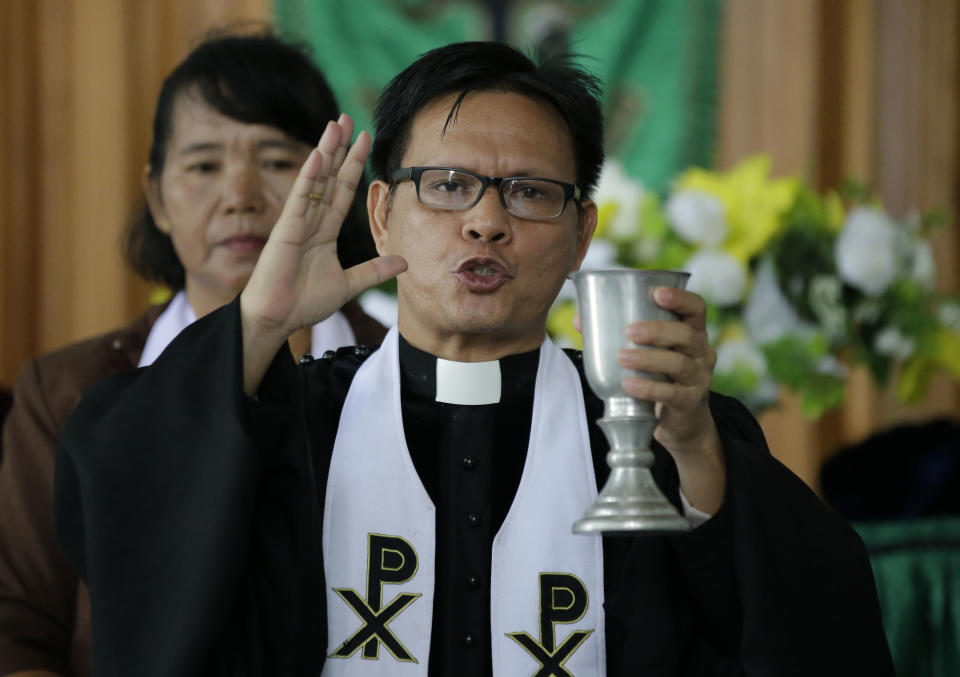 Pastor Lucky Malonda leads a Christian service inside a church at the earthquake and tsunami-hit town of Palu, Central Sulawesi, Indonesia Sunday, Oct. 7, 2018. Christians dressed in their tidiest clothes flocked to Sunday sermons in the earthquake and tsunami damaged Indonesian city of Palu, hoping for answers to the double tragedy that inflicted deep trauma on their community. (AP Photo/Aaron Favila)