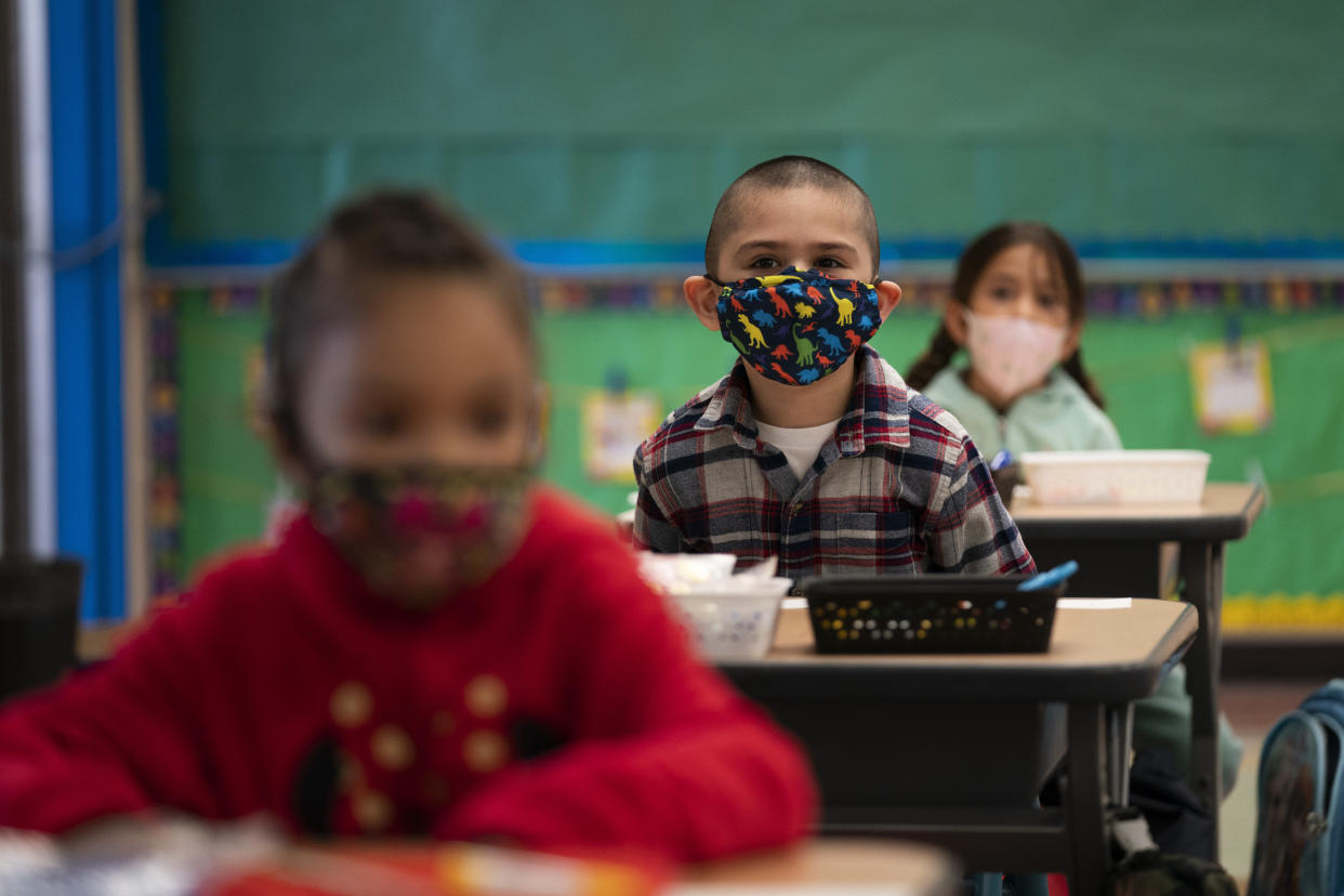 FILE — In this April 13, 2021, file photo, kindergarten students sit in their classroom on the first day of in-person learning at Maurice Sendak Elementary School in Los Angeles. California health officials announced new coronavirus rules for public schools on Monday, July 12, 2021. The new rules eliminate physical distancing while making sure no one will miss class time even if they are exposed to someone with the virus. But the state would continue to require all students and staff to wear masks indoors. (AP Photo/Jae C. Hong, File)