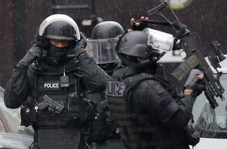 Armed French intervention police prepare their gear at the scene of a shooting in the street of Montrouge near Paris January 8, 2015. REUTERS/Christian Hartmann