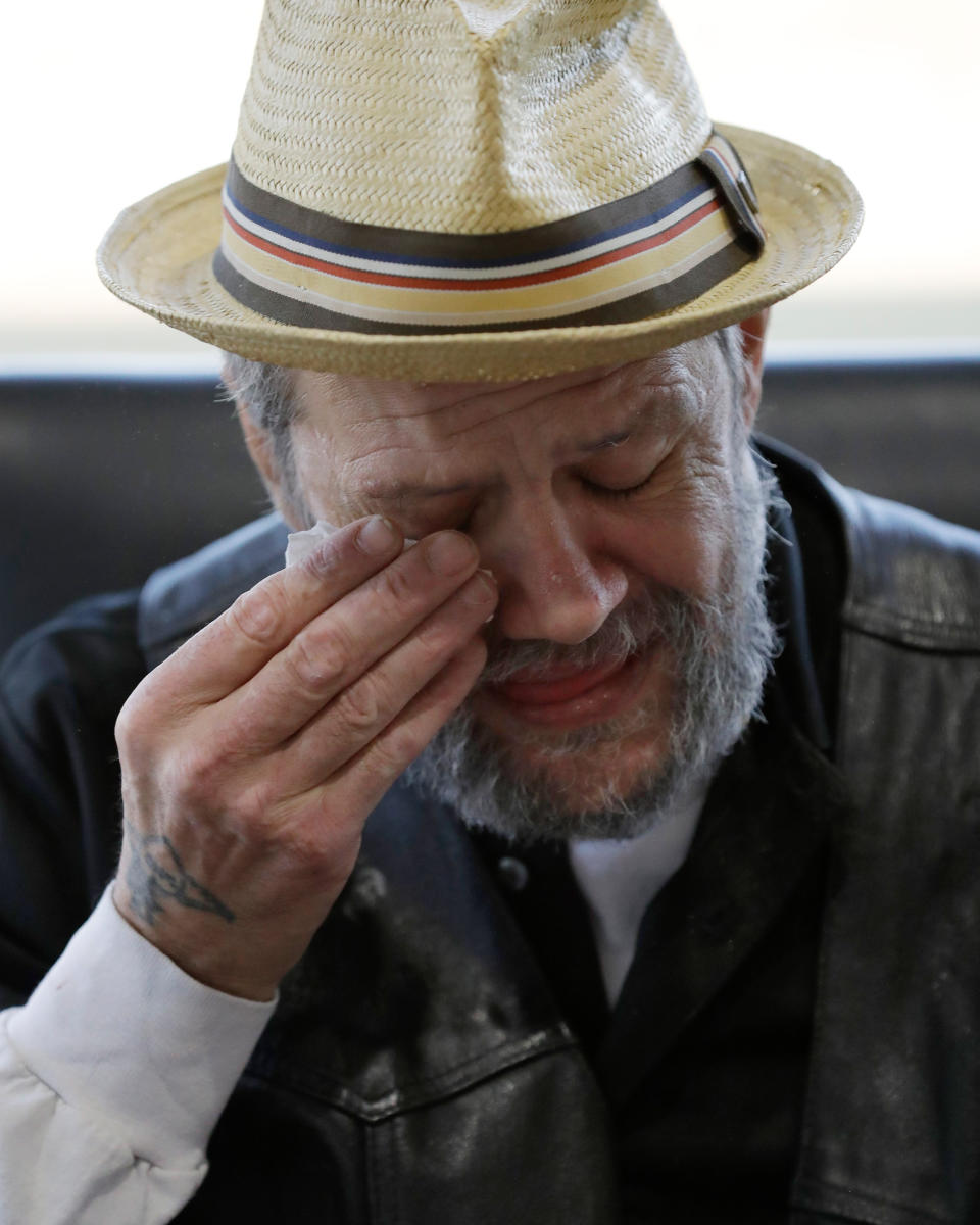 In this Saturday, Dec. 21, 2019 photo, Bobby Goldberg wipes his face at the office of his lawyer, Melissa Anderson, in Bannockburn, Ill. Goldberg has filed a lawsuit claiming he was abused more than 1,000 times in multiple states and countries by the late Donald McGuire, a prominent American Jesuit priest who had close ties to Mother Teresa. (AP Photo/Nam Y. Huh)