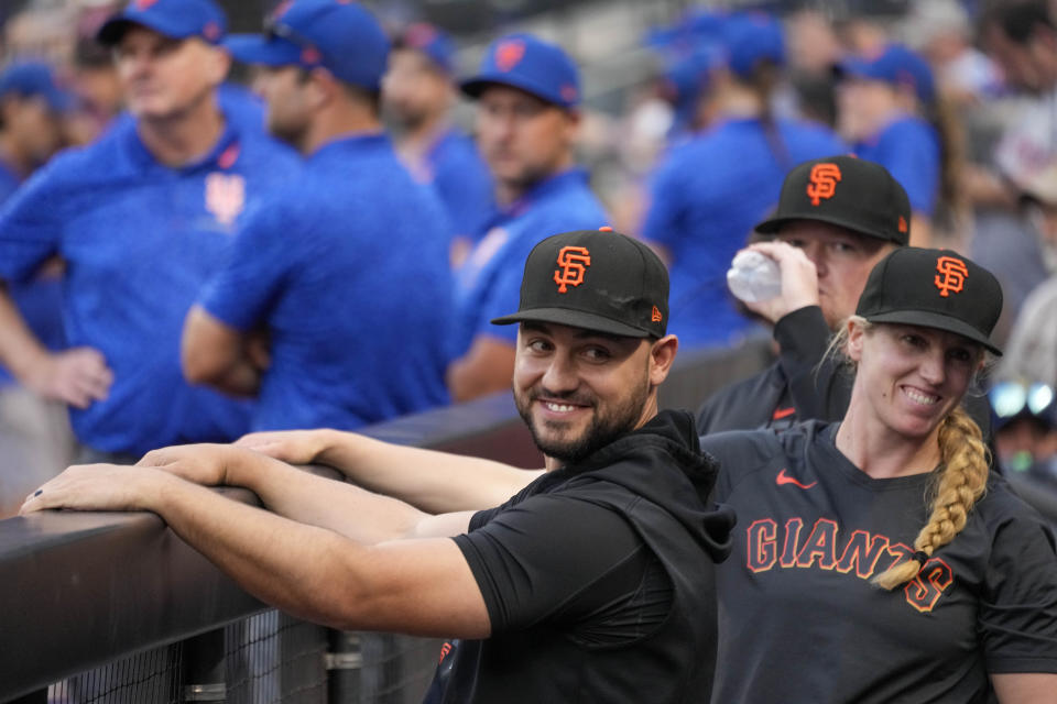 San Francisco Giants right fielder and former New York Mets player Michael Conforto smiles in the dugout before the team's baseball game against the New York Mets on Friday, June 30, 2023, in New York. At right is coach Alyssa Nakken. (AP Photo/Mary Altaffer)