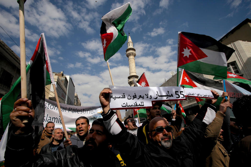 Jordanian protesters affiliated with Jordan's Muslim Brotherhood chant anti-Israel and anti-America slogans during a demonstration in downtown Amman, Jordan, Friday, Feb. 14, 2014. The Arabic writing reads " The Masonic sold out the two banks (refer to West Bank and Jordan) ." Hours before Jordan's King Abdullah II met with U.S. President Barack Obama in California, his Islamist opposition at home has staged its largest protest in several months to reject a peaceful Mideast settlement. (AP Photo/Mohammad Hannon)