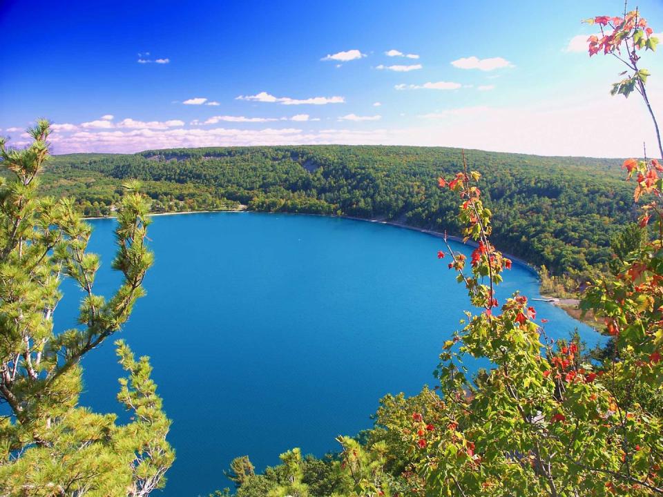 <p><strong>Devil’s Lake State Park </strong></p><p><a href="https://dnr.wi.gov/topic/parks/name/devilslake/" rel="nofollow noopener" target="_blank" data-ylk="slk:Devil’s Lake State Park;elm:context_link;itc:0;sec:content-canvas" class="link ">Devil’s Lake State Park</a> is the largest state park in Wisconsin, located south of Baraboo. The park is known for its 500 foot high quartzite bluffs along the 360 acre Devil’s Lake, which was a result of a glacier depositing terminal moraines that plugged the north and south ends of the gap in the bluffs during the last ice age 12,000 years ago! Visitors enjoy hiking and camping overnight, taking in the history and views.</p>