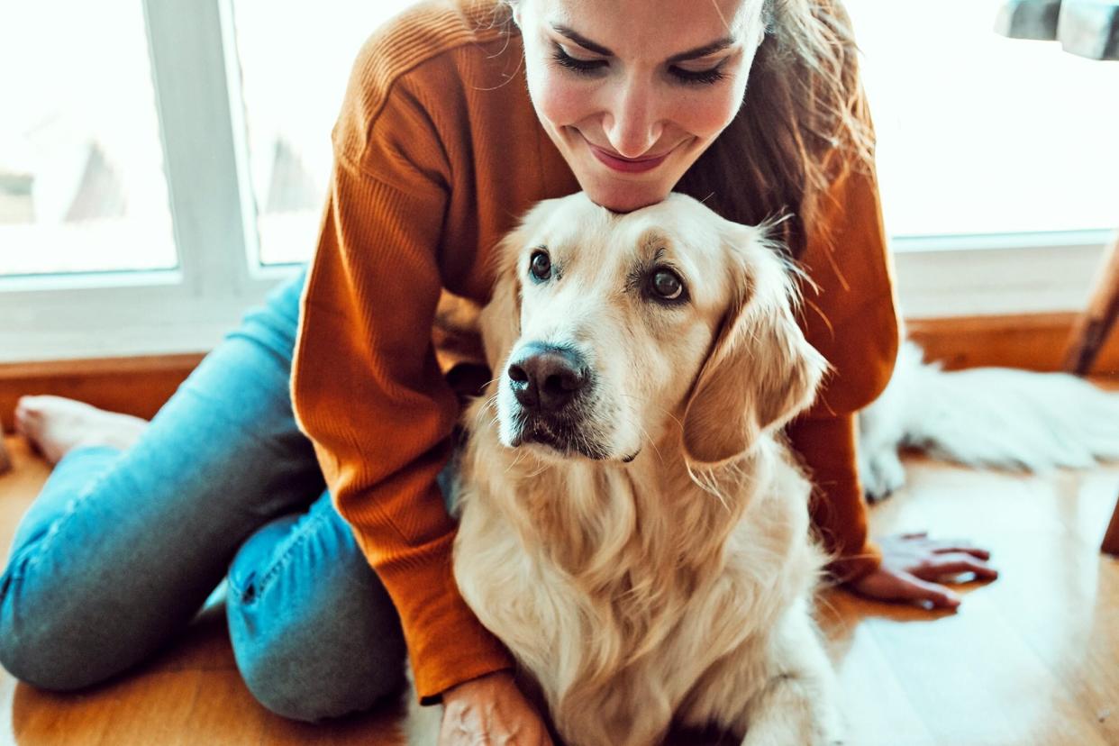woman holding her golden retriever; how do you know if your dog is in pain?
