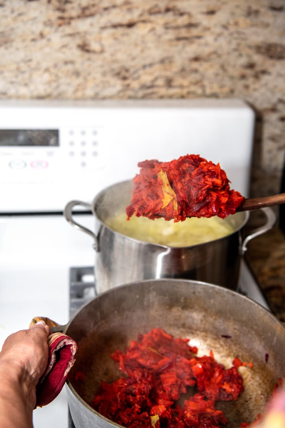 Two pots full of cooking vegetables on a stovetop