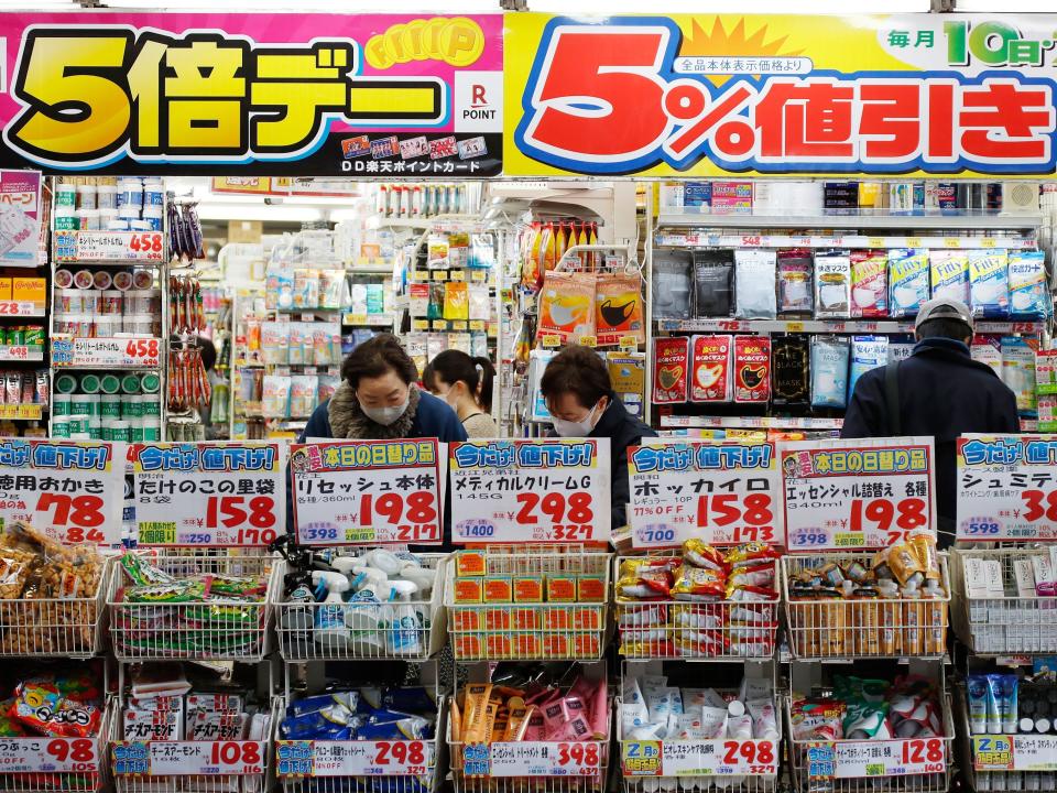 A group of people looking at items in a shop with brightly-colored branding throughout.