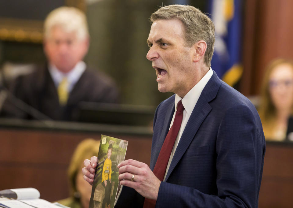 In this Monday, June 3, 2019 photo, 11th Circuit Solicitor Rick Hubbard holds up a photo of Timothy Jones Jr.'s son Nahtahn, 6, while giving the state's closing argument during the murder trial of Jones at the Lexington County Courthouse, in Lexington, Ky. Jurors are again deliberating whether the South Carolina father is guilty of murder in the deaths of his five children. (Jeff Blake/The State via AP, Pool)