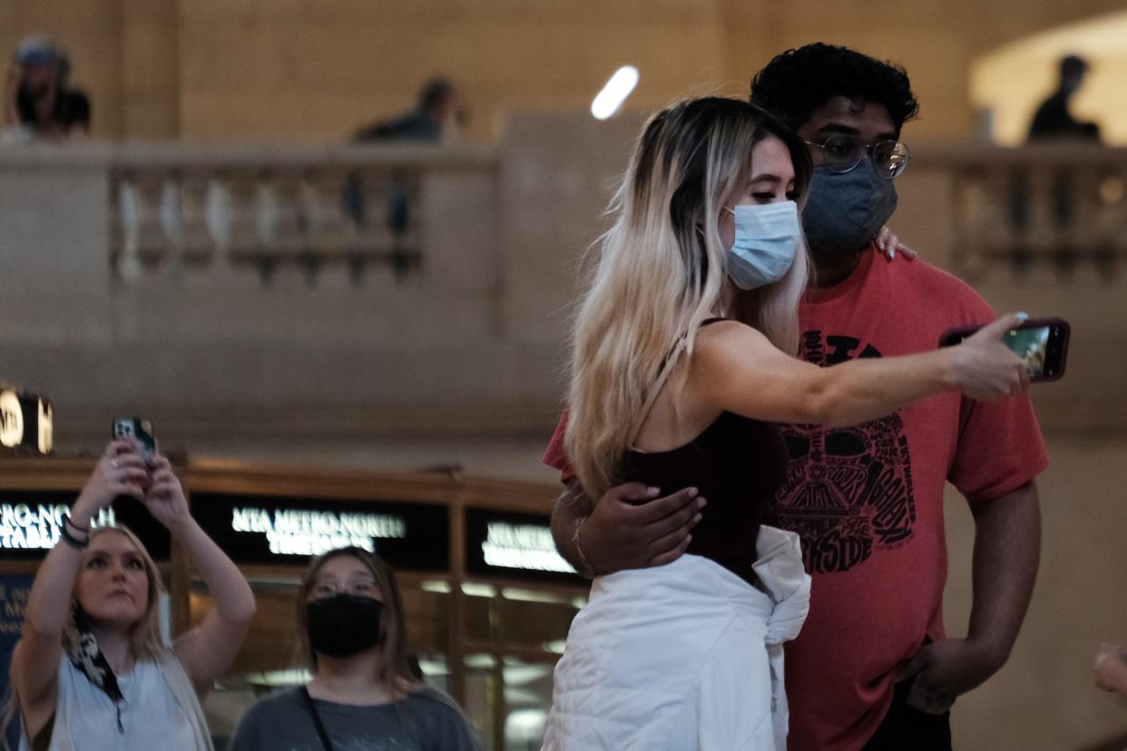 People pose for a photo while wearing masks in Grand Central Terminal in midtown Manhattan, New York