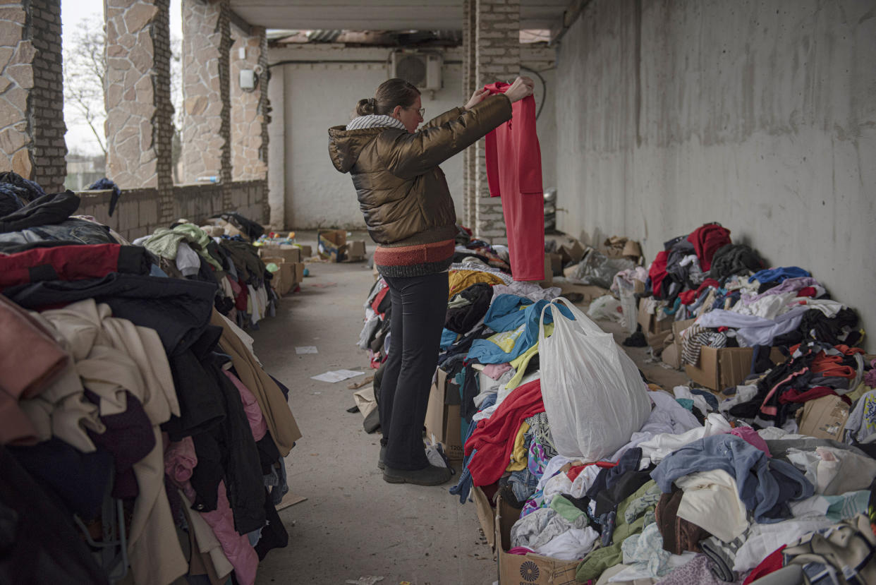 Kateryna, 36, a kitchen worker of the Puscha Vodytsia maternity hospital, looks for clothes at a distribution space in the village of Moshun, outside Kyiv, Ukraine, Friday, Nov. 4, 2022. (AP Photo/Andrew Kravchenko)