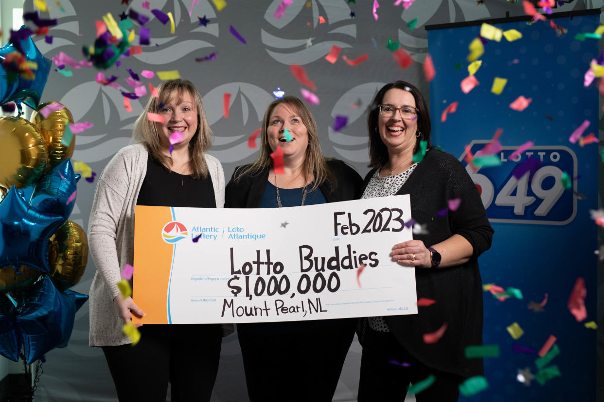 Three woman hold a $1,000,000 lottery check. 