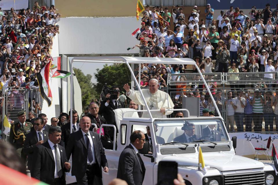 Pope Francis waves to the faithful upon his arrival to attend a mass in Amman