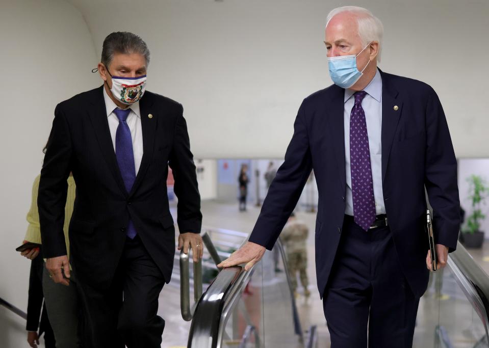 Sen. John Cornyn, R-Texas, talks with Sen. Joe Manchin, D-W.V., while in the U.S. Capitol on Friday.